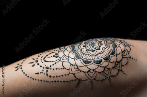 Closeup freshly done henna tattoo on woman's shoulder