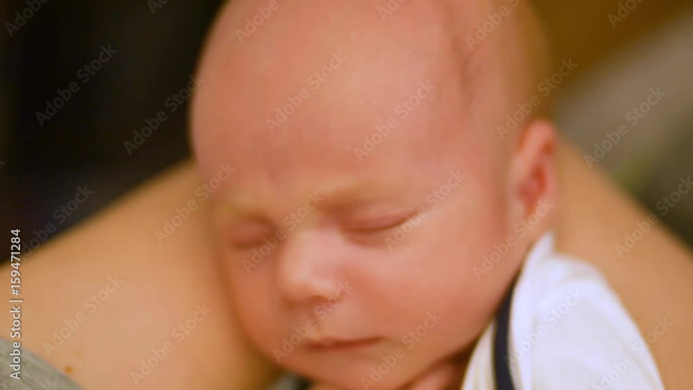 adorable little newborn baby is falls asleep in mother's arms. Close up shot adorable little newborn baby is falls asleep in mother's arms. Close up shot