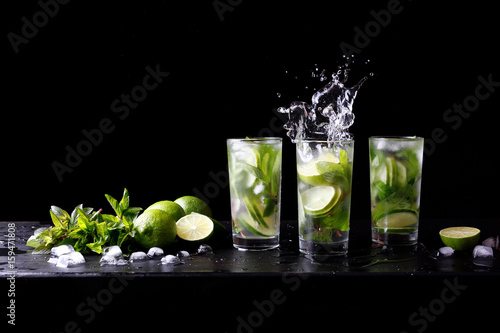 Mojito summer party refreshing tropical cocktail non alcohol drink in highball glass with splash soda water, lime juice, mint leaves, sugar, ice and rum