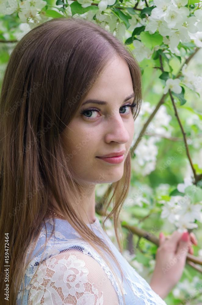 Fototapeta premium Girl posing against a background of flowering trees / Photographed in Russia, in the city of Orenburg