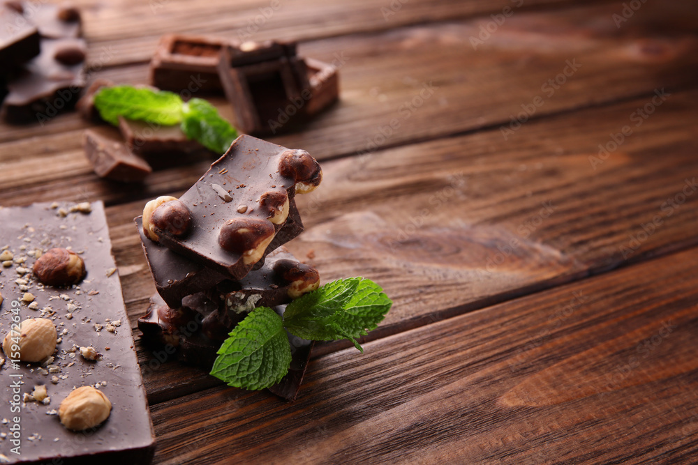 Fototapeta premium Broken chocolate pieces with mint on table