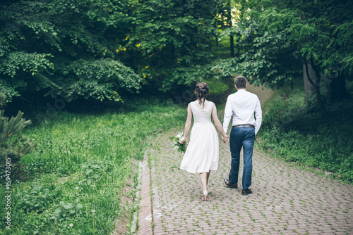 man and woman walking in park in elegnance dress