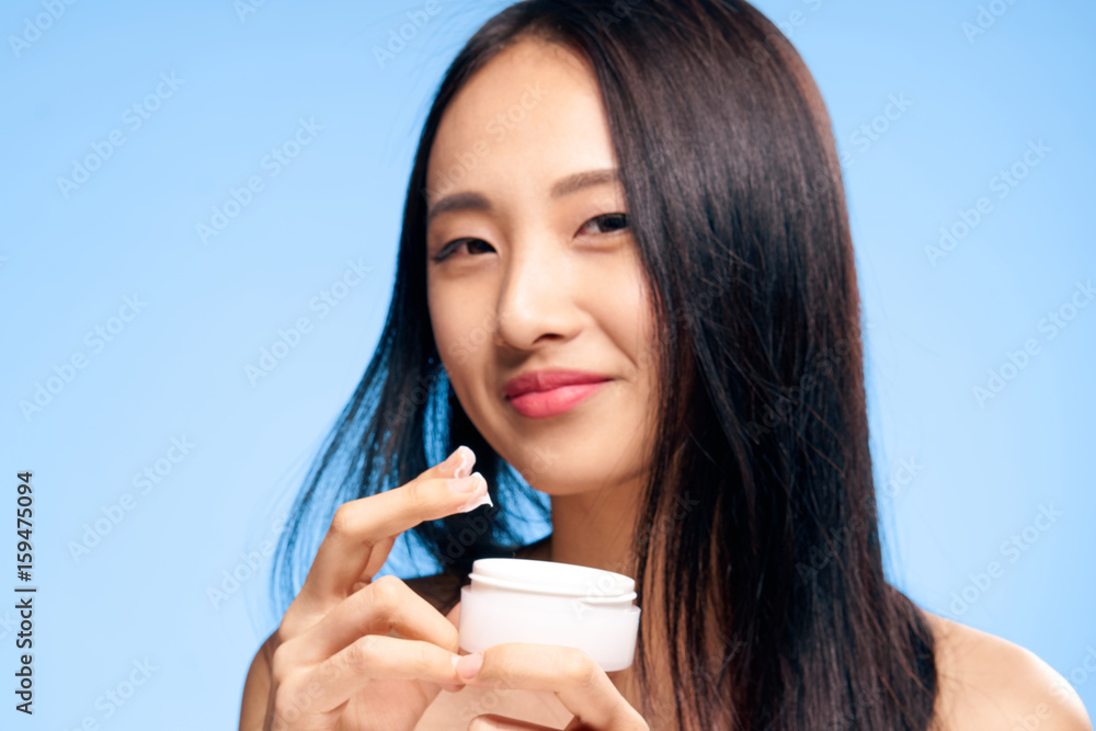 Facial, woman with cream on blue background portrait Facial, woman with cream on blue background portrait