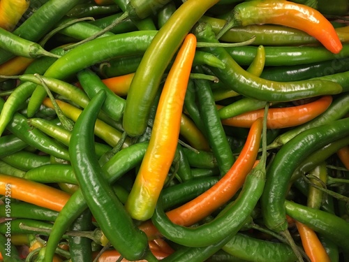 Top view background of green hot chili peppers in a pile