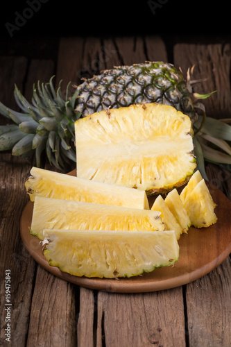 Ripe pineapple and pineapple slices on a wooden background tropical fruits