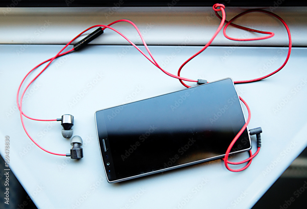 mobile phone and headset on the table in a train mobile phone and headset on the table in a train