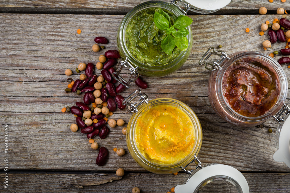 Selection of colorful hummus in jars Selection of colorful hummus in jars