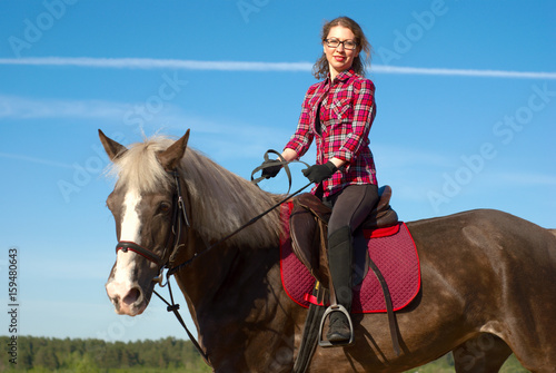 Smiling women on horseback.