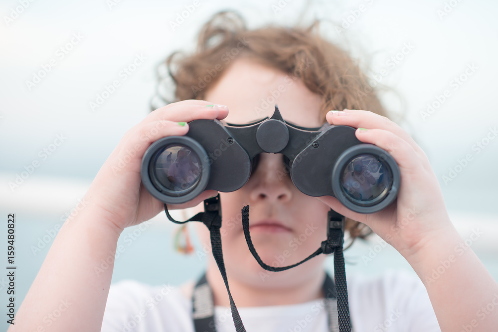 Beautiful young girl on boat looking directly at camera through binoculars Beautiful young girl on boat looking directly at camera through binoculars