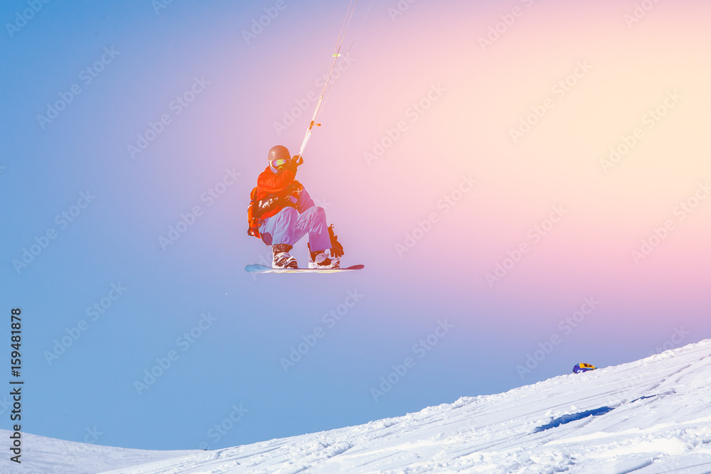 Snowboarder with a kite on fresh snow in the winter in the tundra of Russia against a clear blue sky. Teriberka, Kola Peninsula, Russia. Concept of winter sports snowkite. Snowboarder with a kite on fresh snow in the winter in the tundra of Russia against a clear blue sky. Teriberka, Kola Peninsula, Russia. Concept of winter sports snowkite.