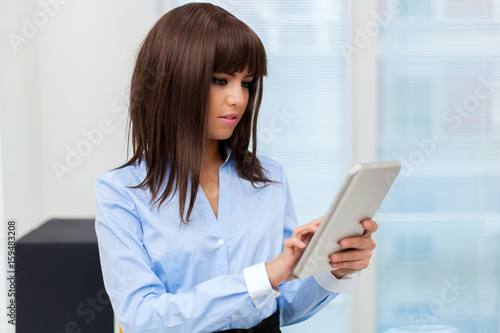 Businesswoman holding a digital tablet © Minerva Studio