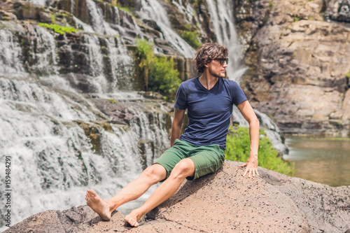 Man hiker, tourist on the background of Amazing Pongour Waterfall is famous and most beautiful of fall in Vietnam. Not far from Dalat city estimate 45 Km. Dalat, Vietnam photo