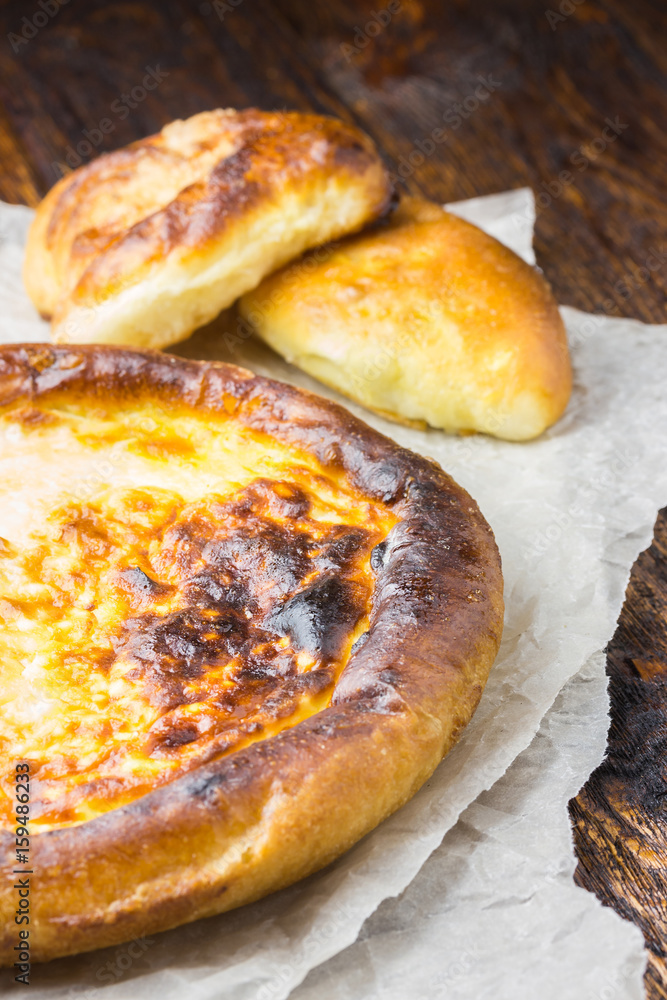  Traditional pastry - vatrushka on parchment paper on wooden table. 
