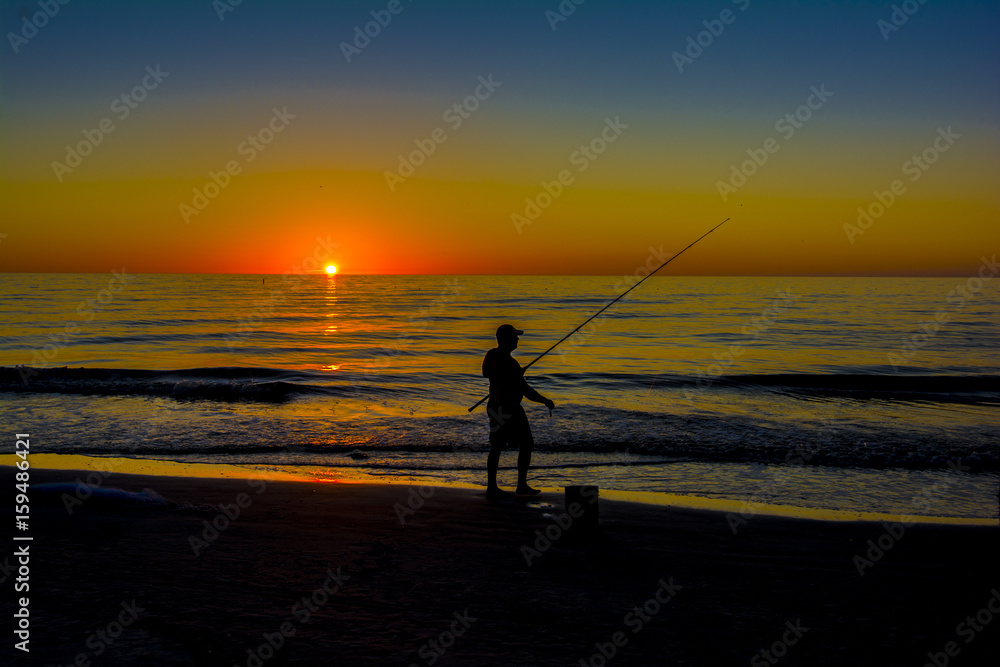 silhouett man fishing at the beach in surf