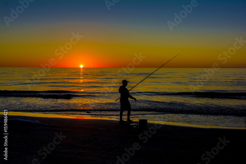 silhouett man fishing at the beach in surf