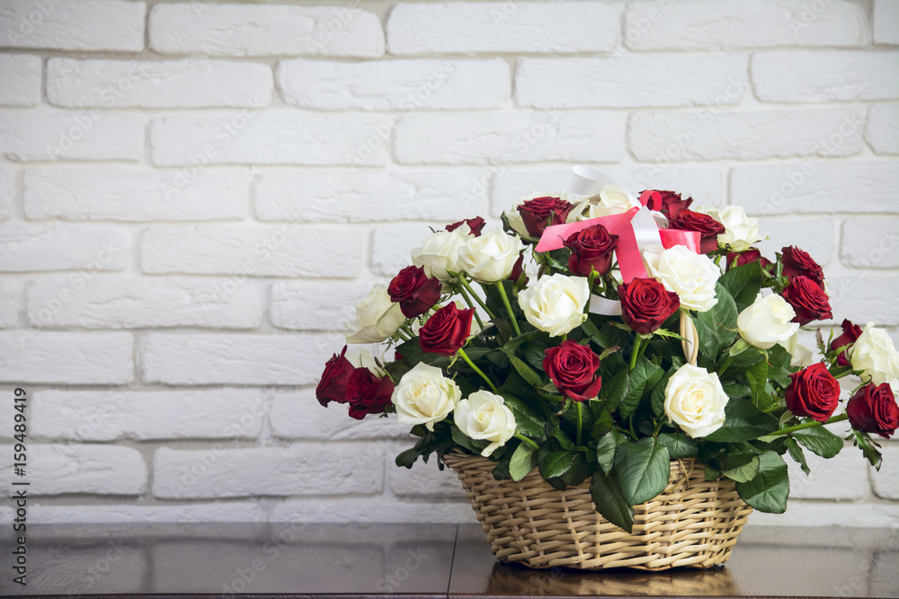 Obraz premium Bouquet of roses in a wooden basket 