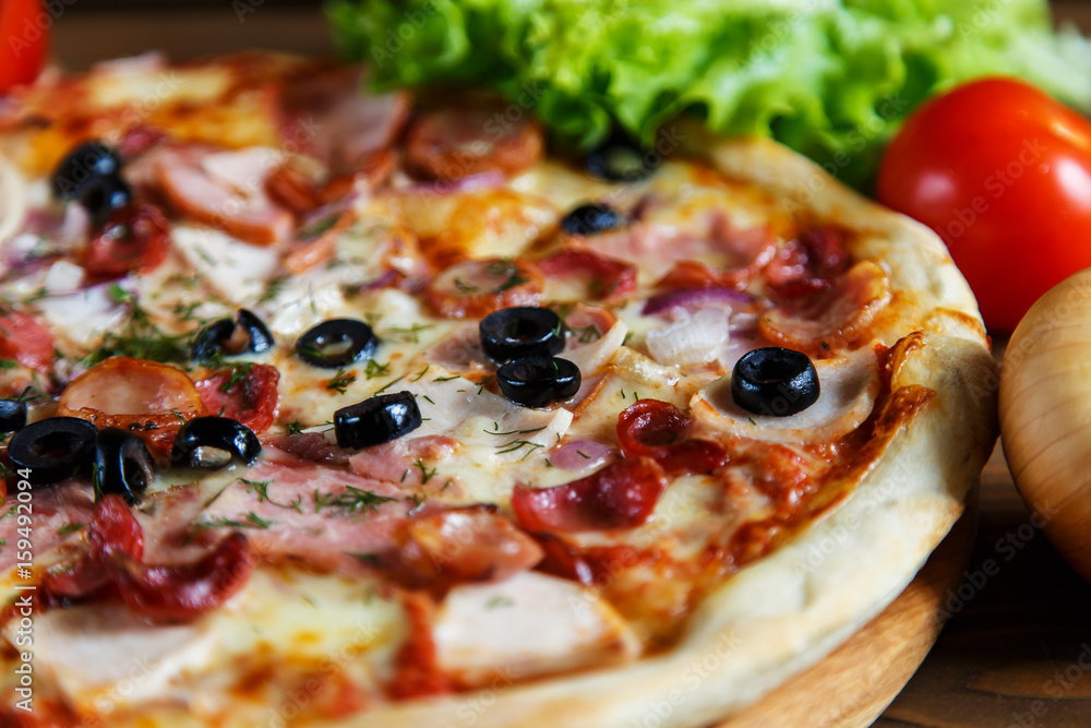 Delicious homemade pizza with mozzarella, ham, olives and fennel. Delicious homemade pizza with mozzarella, ham, olives and fennel.