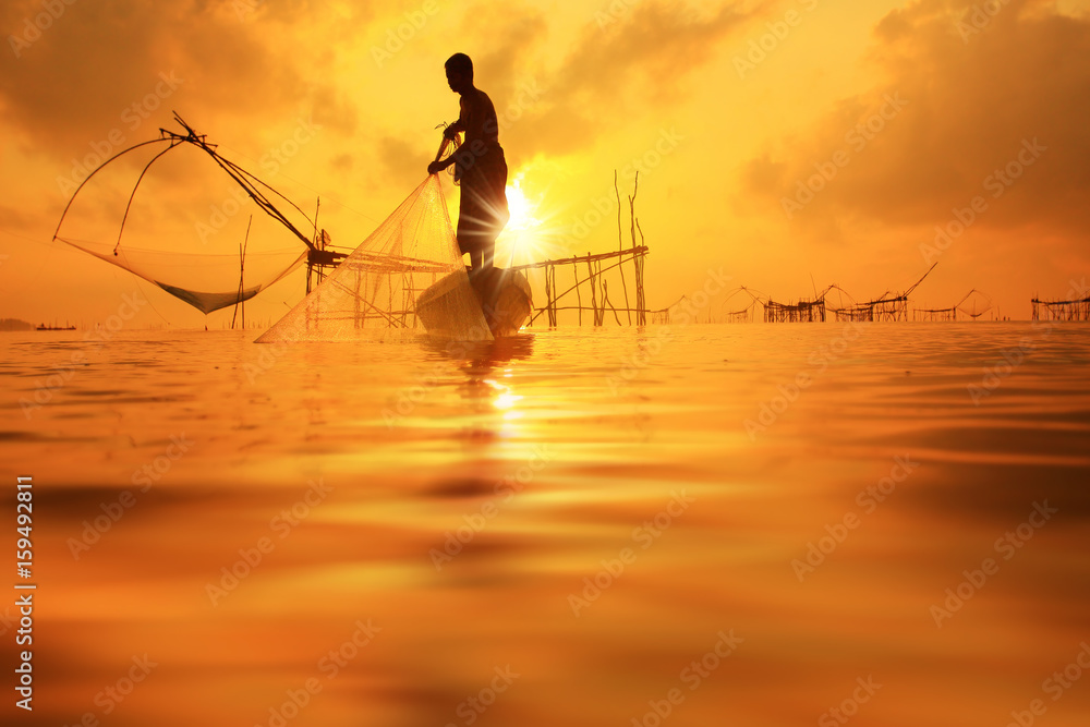 Φωτογραφία Fishermen on boat fishing with a fishnet,the old traditional equipment of Thai fishery