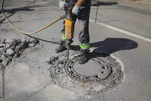 Bilde på lerret Worker at construction site demolishing asphalt with pneumatic jackhammer