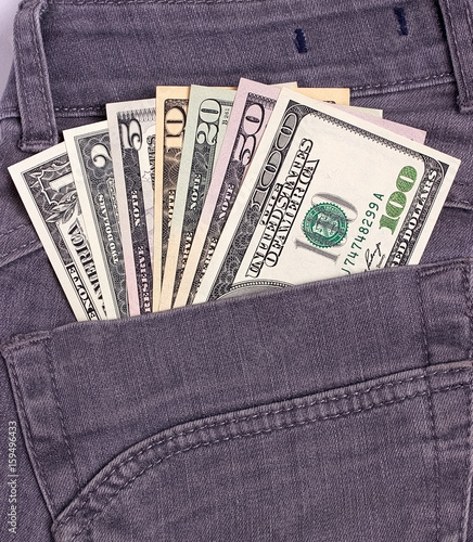 Dollars bills in black jeans back pocket.
