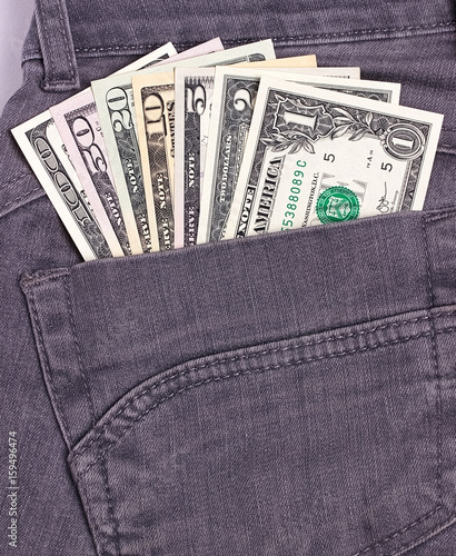 Dollars bills in black jeans back pocket.