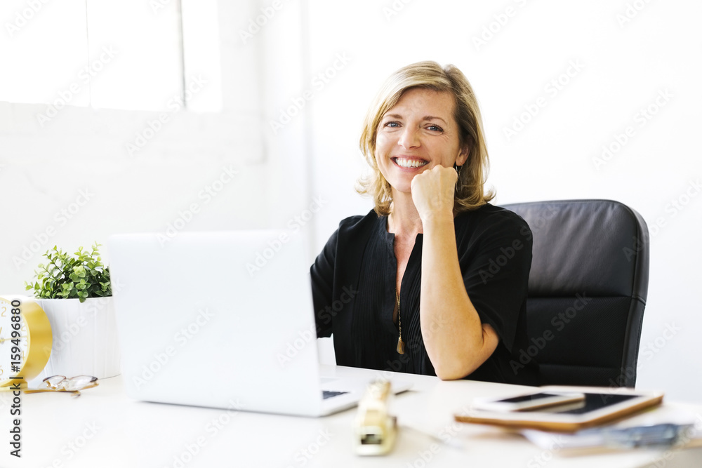 Portrait of Mature woman in office with hand on chin Portrait of Mature woman in office with hand on chin