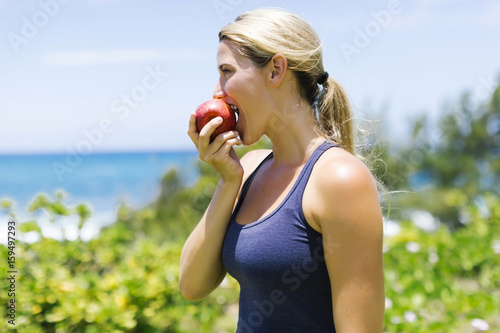 Blonde beautiful woman eating fresh apple photo