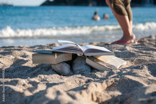 Reading open book at beach near the sea during summer vacation