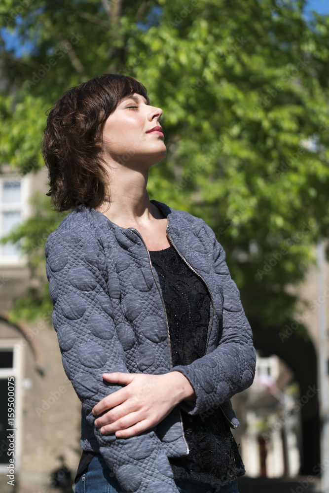Woman daydreaming in warm sunlight Woman daydreaming in warm sunlight