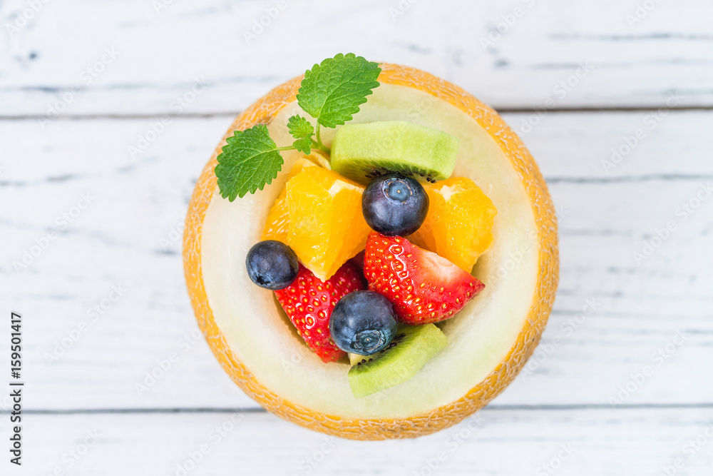 Fruit salad in melon on wooden table. Top view Fruit salad in melon on wooden table. Top view