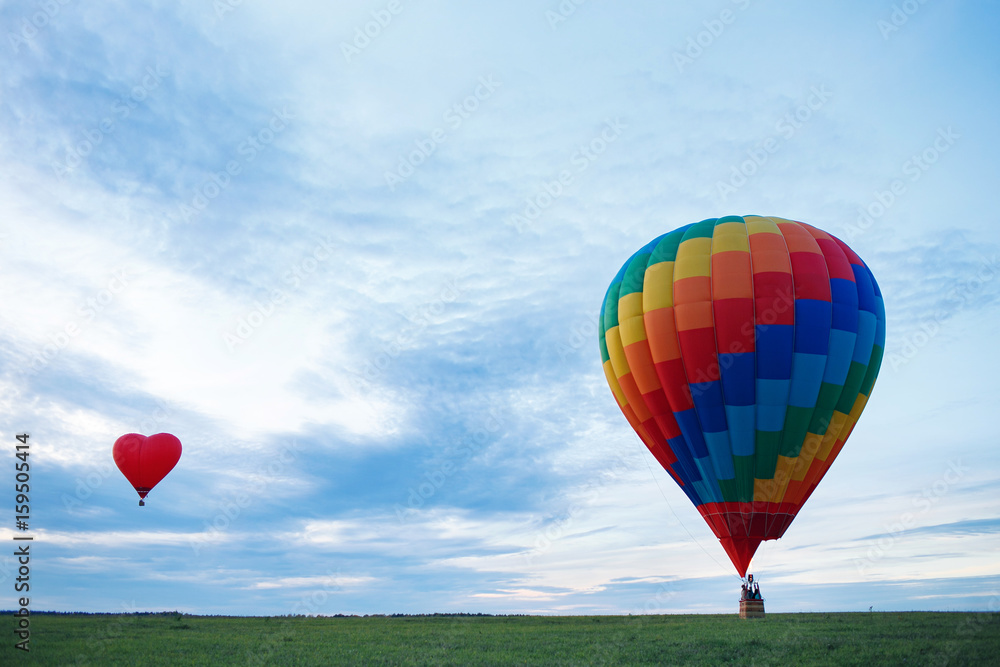 Obraz premium Colorful hot air balloon is flying at sunrise