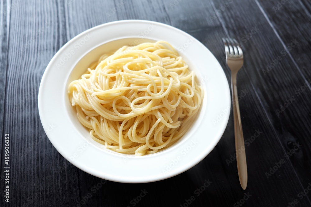 Pasta spaghetti cooked in a dish on black background Pasta spaghetti cooked in a dish on black background