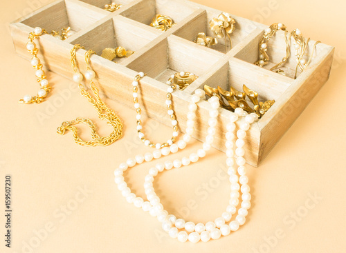 Jewelry background. Gold jewelry and pearls in a box. Copy Space. Wood jewelry box.
