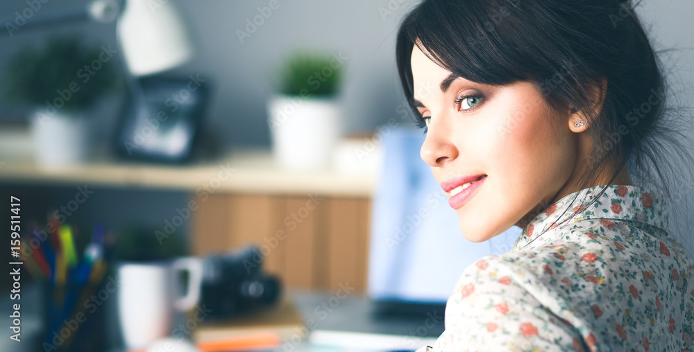 Portrait of young woman sitting at desk Portrait of young woman sitting at desk