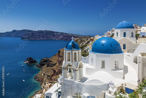 Fototapeta Naklejka Na Ścianę i Meble -  Blue domed churches in the village of Oia, Santorini (Thira), Cyclades Islands, Aegean Sea, Greece