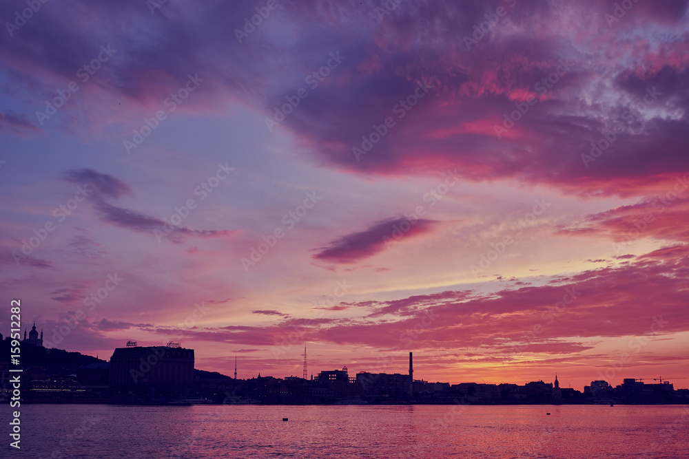 Beautiful clouds in the evening sky over the river in the rays of the setting sun Beautiful clouds in the evening sky over the river in the rays of the setting sun