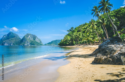 Sandy Beach with Palm Shadows, Huge Rocks in Background, El Nido, Palawan, Philippines © Igor Tichonow