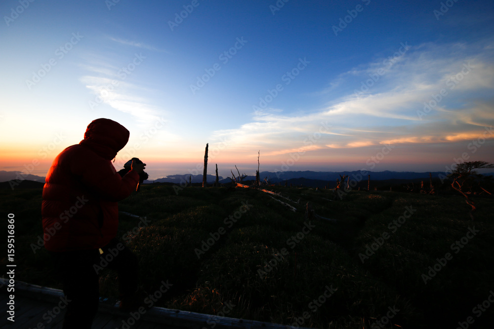 man watching the sunrise from the mountain man watching the sunrise from the mountain