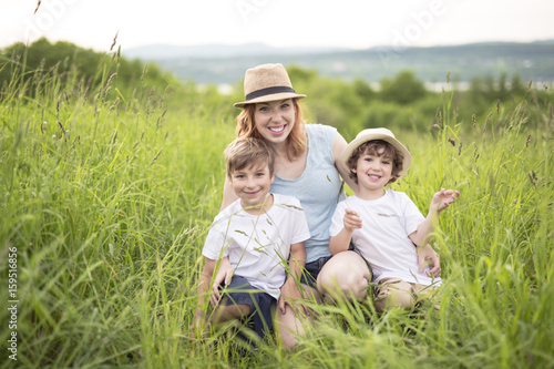 Cute kid boy with his mother on a summer meadow
