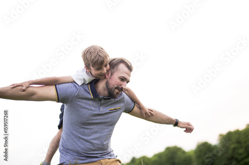 Father and son having fun outdoors in the meadow