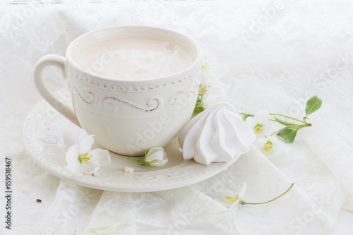 Romantic composition with tea cup, zephyr and apple flowers