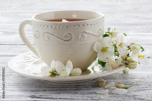 cup of tea with spring flower cherry blossom on a wooden rustic background