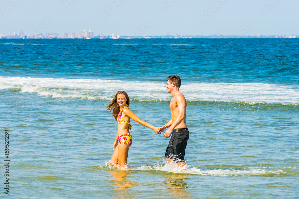 Young American Couple traveling, relaxing on the beach in New Jersey, USA Young American Couple traveling, relaxing on the beach in New Jersey, USA