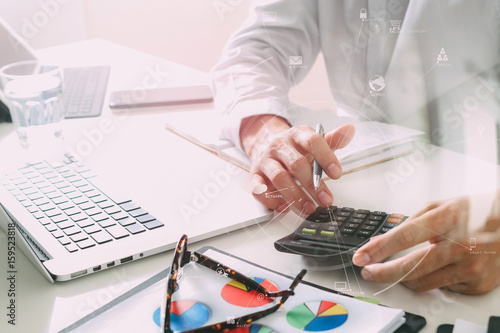 businessman hand working with finances about cost and calculater and latop with mobile phone on withe desk in modern office