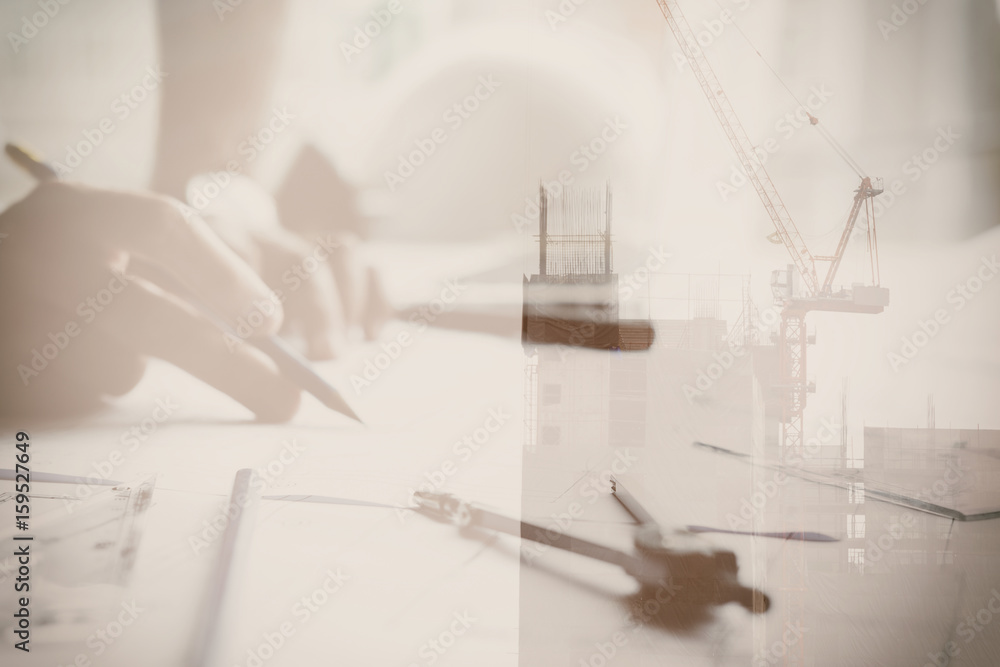 Architect working on real estate project at workplace. Male engineer hand working with living house blueprint at office. Business, people, construction and building concept double exposure with crane Architect working on real estate project at workplace. Male engineer hand working with living house blueprint at office. Business, people, construction and building concept double exposure with crane