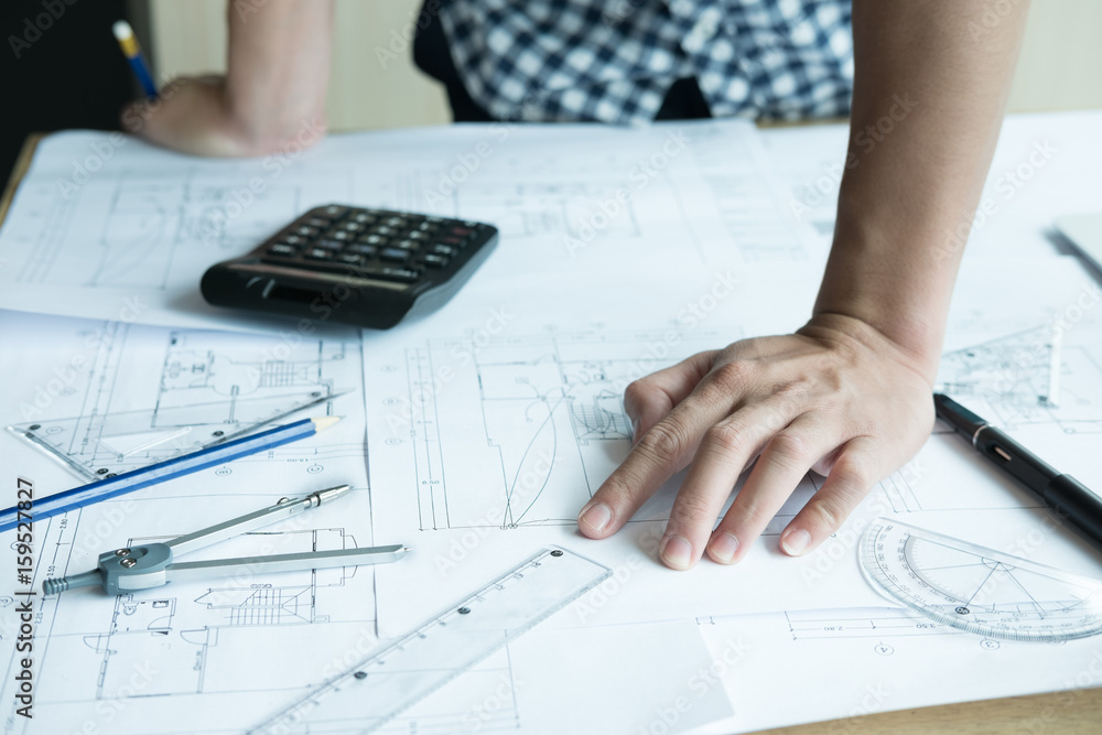 Architect working on real estate project at workplace. Male engineer hand working with living house blueprint at office. Business, people, construction and building concept Architect working on real estate project at workplace. Male engineer hand working with living house blueprint at office. Business, people, construction and building concept