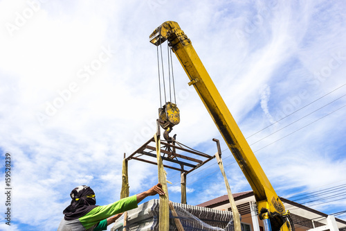 Photos construction site men working crane load tile roof for building