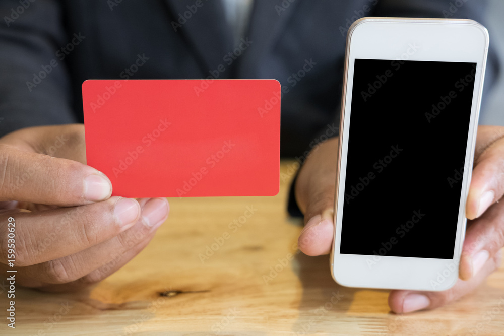 male showing a credit card and mobile smart phone for online shopping. businessman purchase goods from internet. man make payment on bank website male showing a credit card and mobile smart phone for online shopping. businessman purchase goods from internet. man make payment on bank website