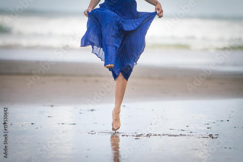 outdoor portrait of young beautiful woman in blue gown posing on natural background