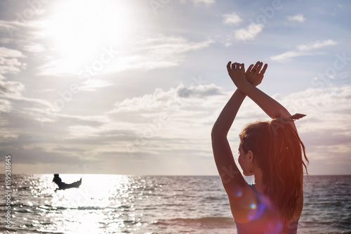 Young woman enjoying beautiful sunset on the beach photo